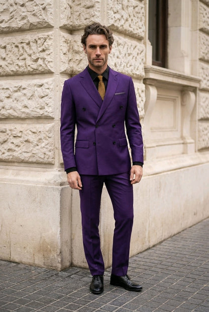 A man wearing a vibrant purple double-breasted suit with a black shirt and a gold tie, standing outdoors against a light-colored stone building.