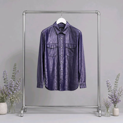 A purple crinkled leather button-up shirt hanging on a white hanger from a silver metal clothing rack, with decorative vases of lavender on both sides against a neutral gray background.