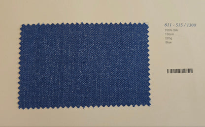 A rectangular blue fabric swatch with zigzag-cut edges, shown on a white card with a barcode and small printed text below it.