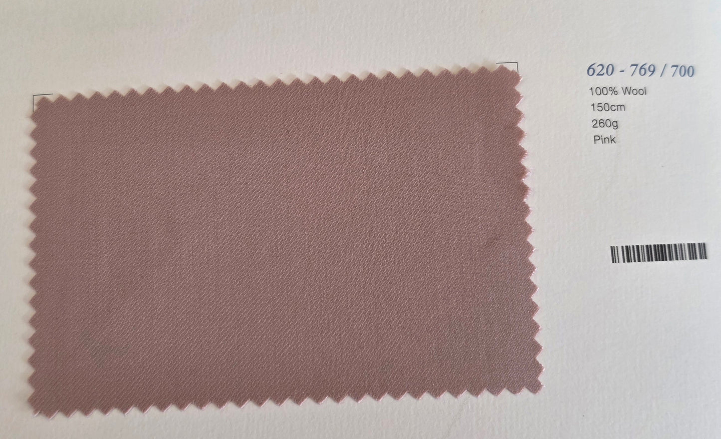 A rectangular fabric swatch of dusty pink wool with serrated edges, displayed on a white background with printed details on the right side.