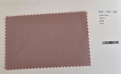 A rectangular fabric swatch of dusty pink wool with serrated edges, displayed on a white background with printed details on the right side.