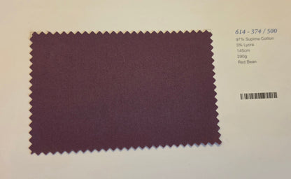 A rectangular fabric swatch with serrated edges in a muted burgundy-purple color, displayed on a white background with printed text and a barcode to the right.