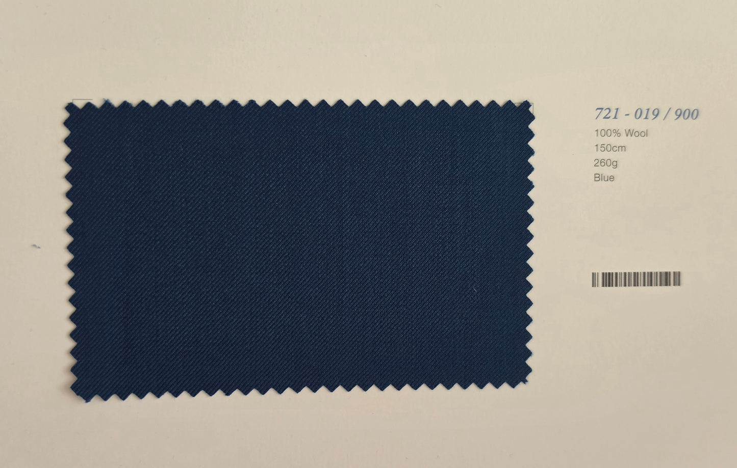 A rectangular fabric swatch with zigzag-cut edges in dark blue wool, shown on a light beige background with printed text reading '721-019/900', '100% Wool', '150g', '280g', and 'Blue'.