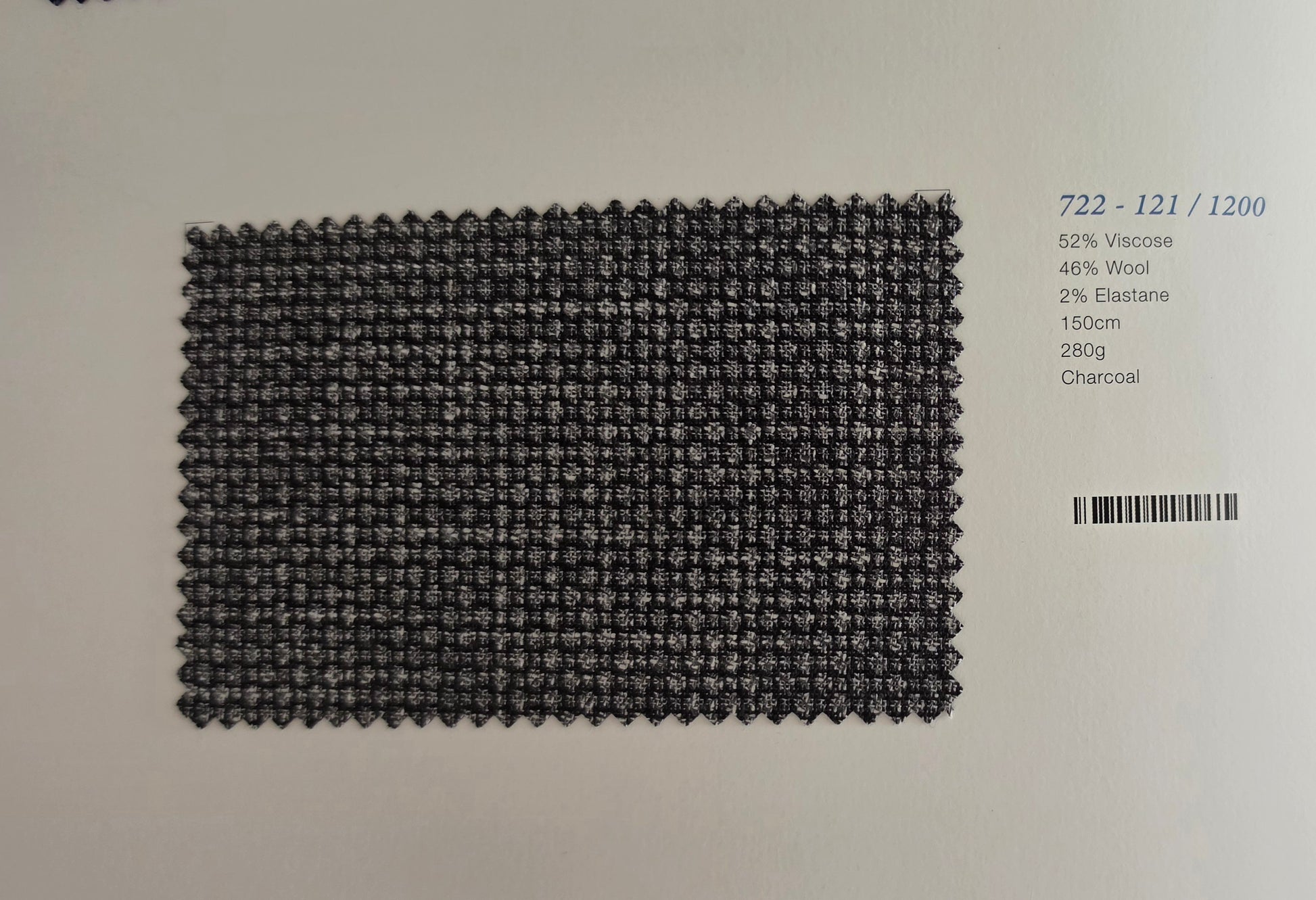 A rectangular woven fabric swatch in charcoal gray, displayed on a white background with printed product details on the right side.