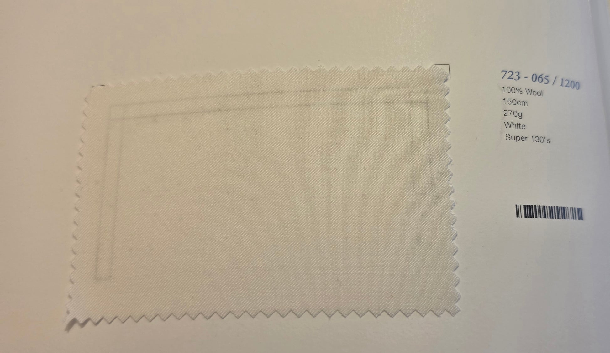 A square fabric swatch of off-white wool with serrated edges, displayed on a white background next to printed product details including '723 - 065 / 1200' and '100% Wool 1500m 270g White Super 130s'.