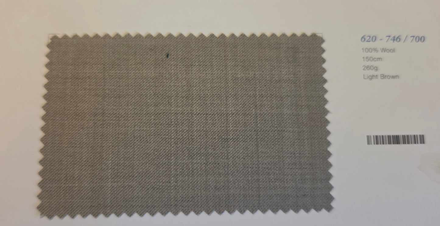 A square fabric swatch with serrated edges in a light brown woven material, shown on a white background with printed text and a bar-code to the right.