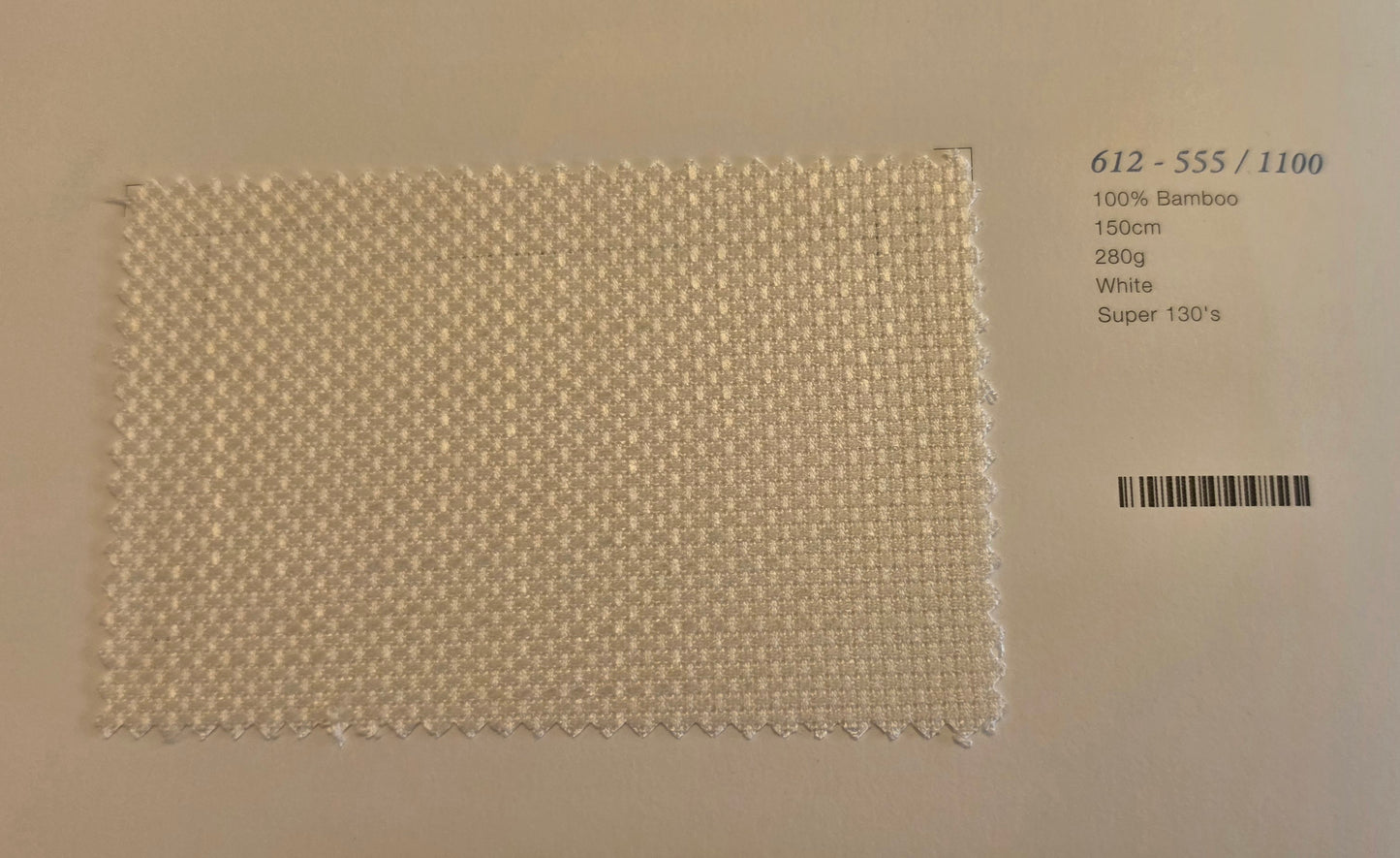 A square woven bamboo fabric swatch in white, displayed on a light beige background with printed product details on the right side.