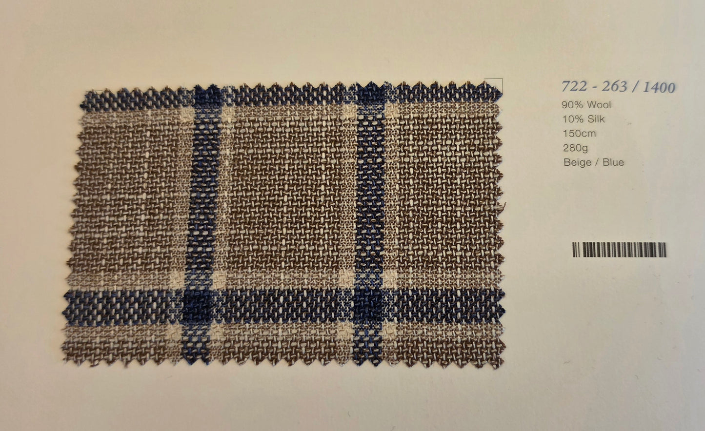 A woven fabric swatch card showing a beige and blue plaid pattern, with text on the right indicating composition and barcode.