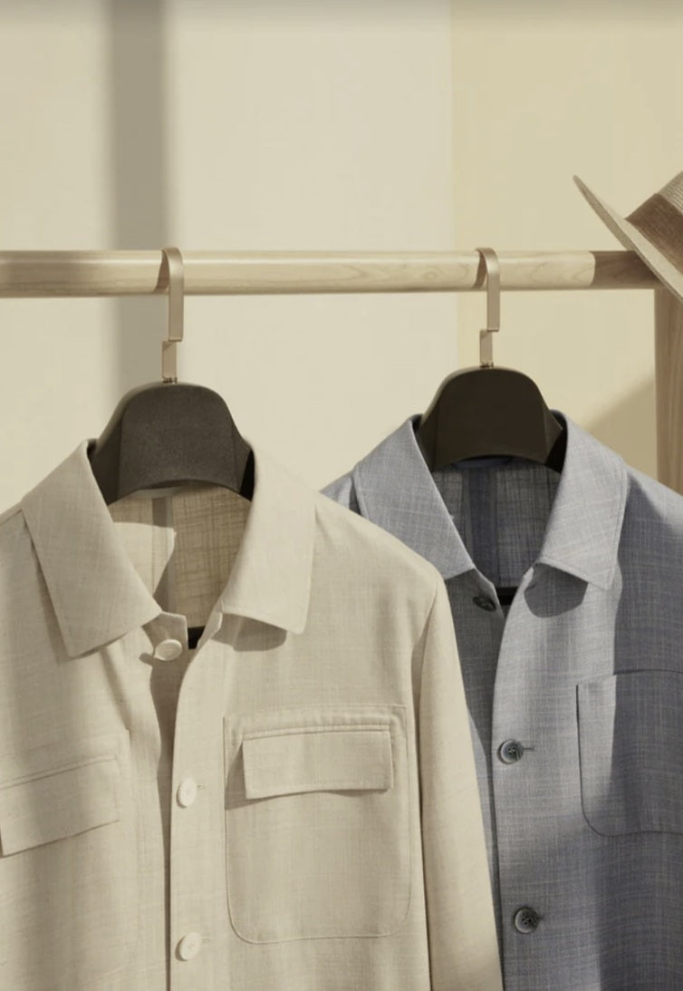 Bamboo shirts hanging on a rack against a neutral background