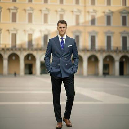 Man in a blue suit standing in front of a large building with arches.