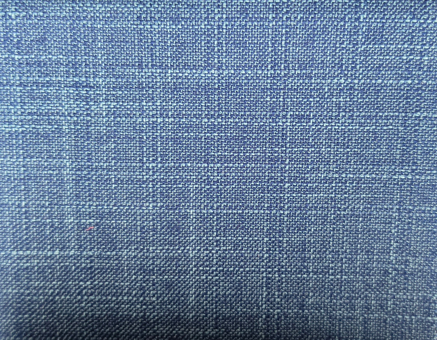 A close-up of a blue woven fabric with a subtle plaid pattern, showing the texture and weave detail.
