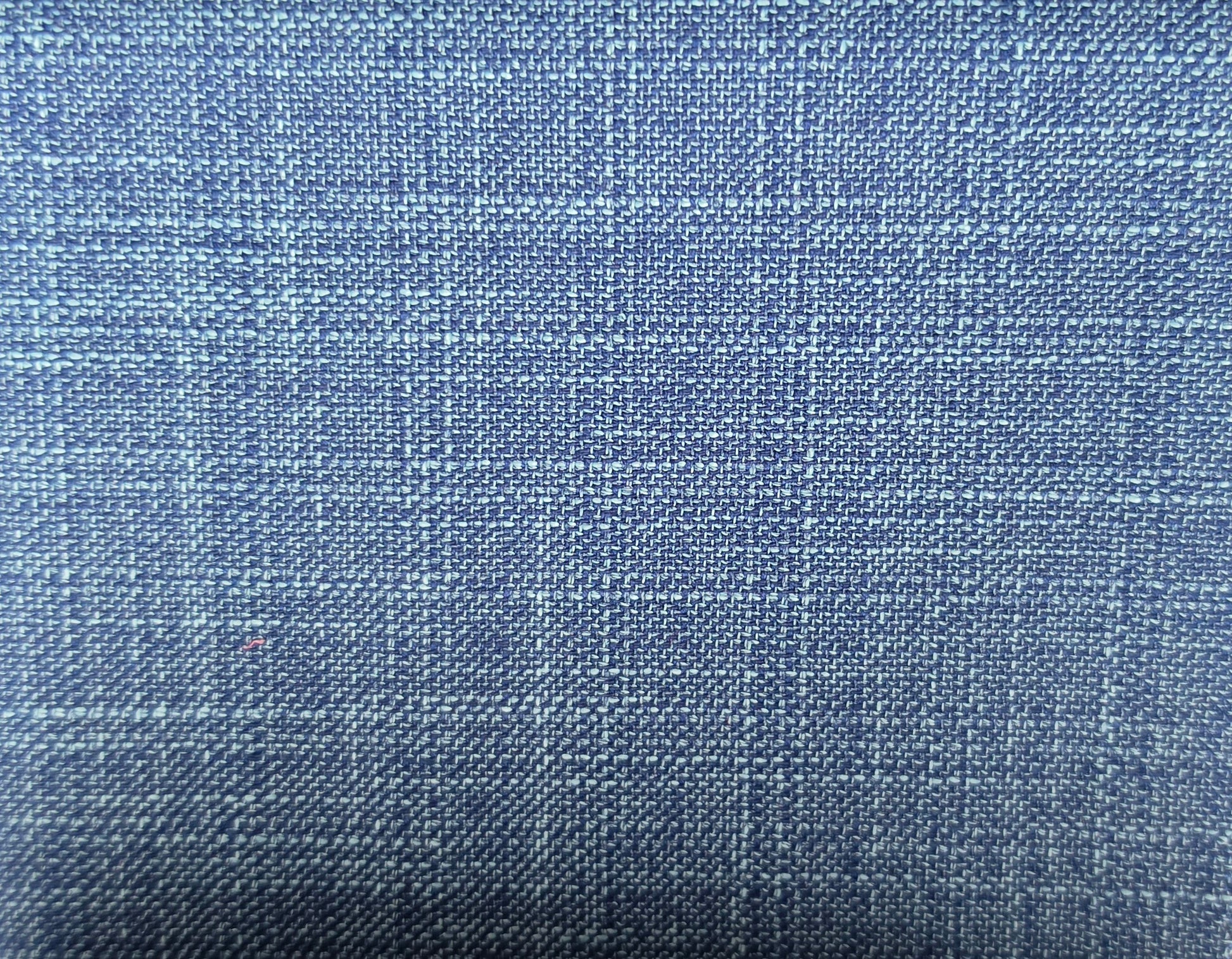 A close-up of a blue woven fabric with a subtle plaid pattern, showing the texture and weave detail.