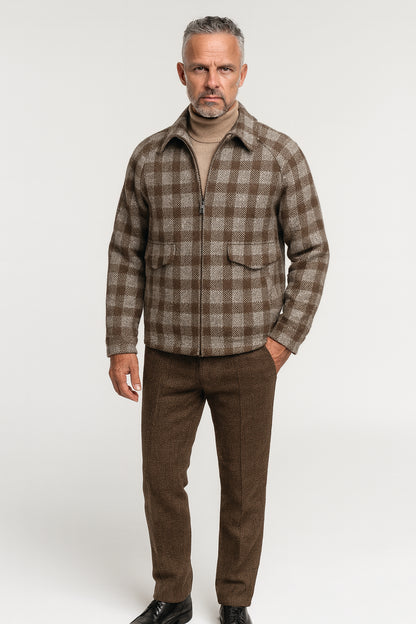 Man wearing a brown plaid shirt and pants on a white background