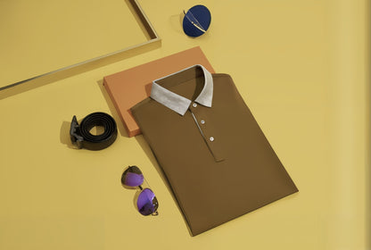 Brown polo shirt with white collar, black belt, and sunglasses on a yellow background