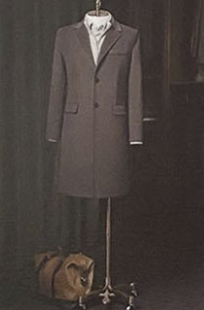 Brown overcoat on a mannequin against a dark background