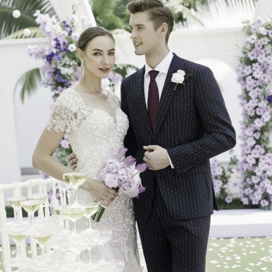 Couple in wedding attire standing together with floral decorations and glasses of champagne.