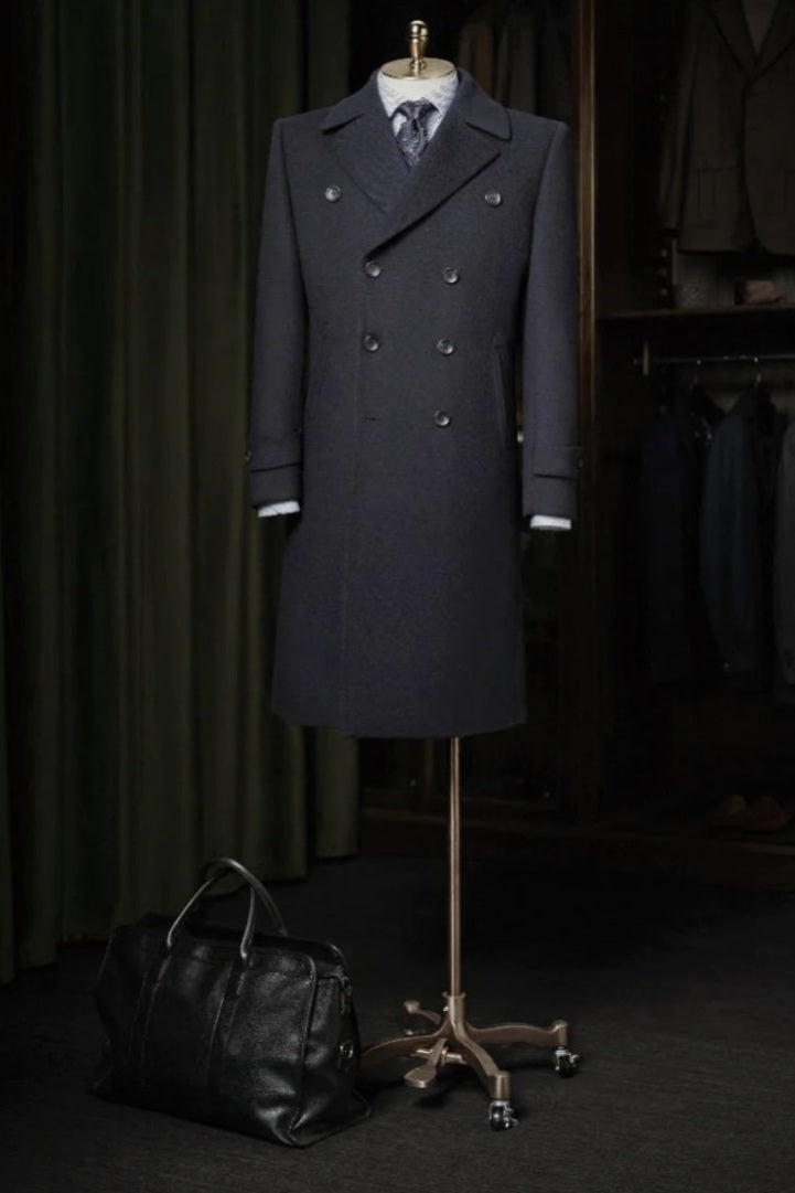 Dark Navy overcoat on a mannequin with a black bag on a dark background