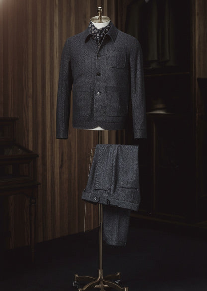 Dark gray textured jacket displayed on a mannequin against a dark background
