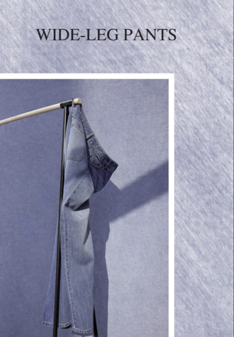 Denim wide-leg pants hanging on a rod against a textured blue background with 'WIDE-LEG PANTS' text.