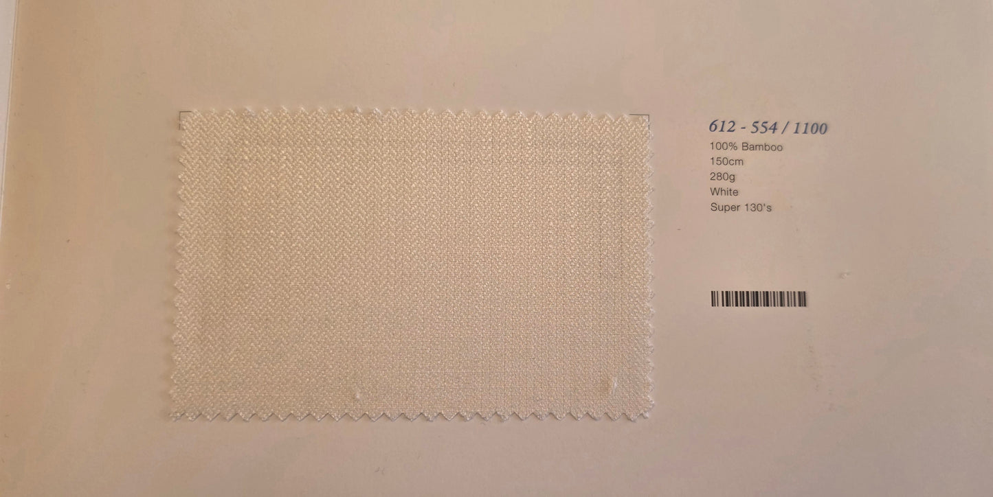 A square fabric swatch of off-white woven material with a zigzag stitched border, displayed on a light beige background next to printed product details including a barcode and text '612 - 554 / 1100'.