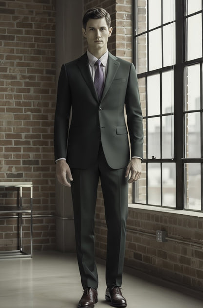 Man wearing a gray suit standing in a room with brick walls and large windows.