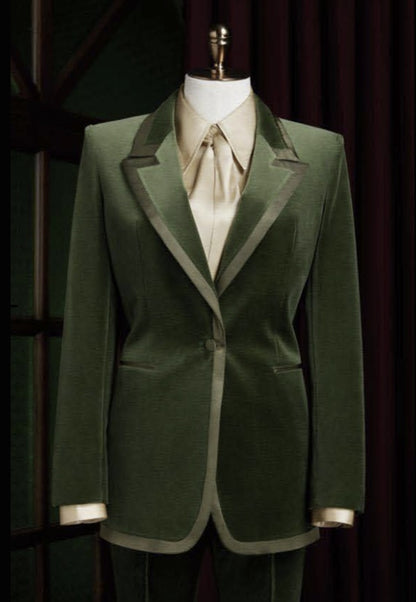 Green blazer with beige trim on a mannequin against a dark background