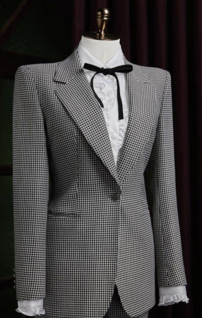 Grey checkered blazer on a mannequin with a white shirt and black bow tie against a dark background