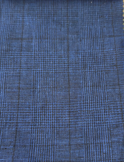 A close-up of a blue woven fabric with a subtle black plaid or grid pattern.