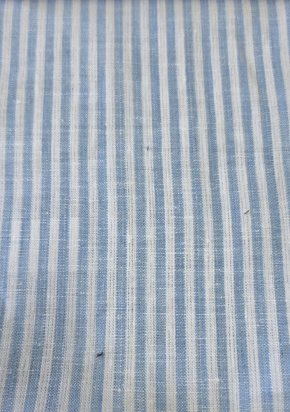 A close-up of a woven fabric with vertical stripes in light blue and off-white, showing a textured linen-like weave.
