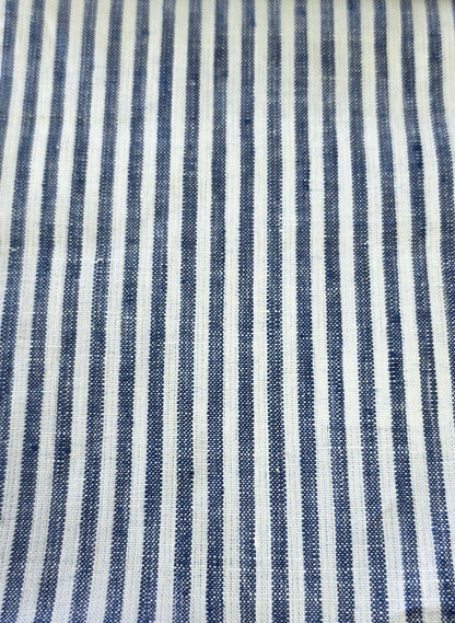 A close-up of a woven fabric with vertical navy blue and off-white stripes, showing the textile texture.