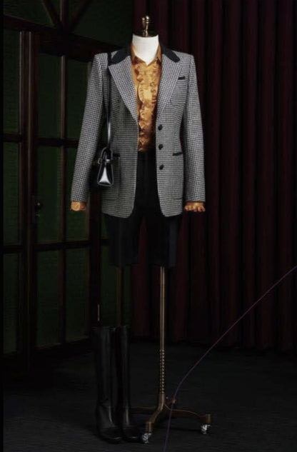 Ladies grey blazer, patterned shirt, and black Trousers against a dark background