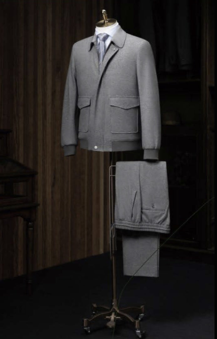 A medium grey casual jacket and plus medium grey trousers displayed on a mannequin, featuring a slim fit with single button fastening, patched flapped pockets, and grey ribbing on the hem.