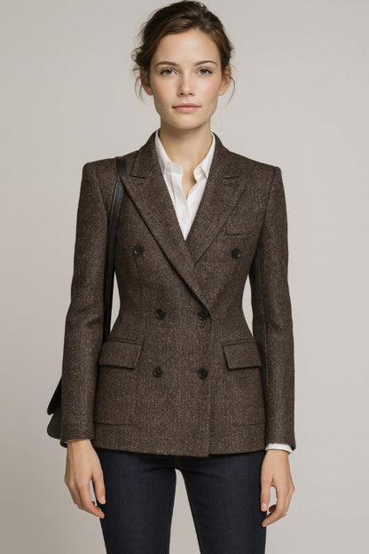 Lady wearing a brown blazer over a white shirt on a plain background