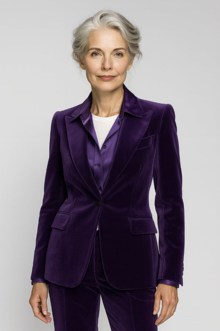 Lady wearing a purple velvet suit against a white background