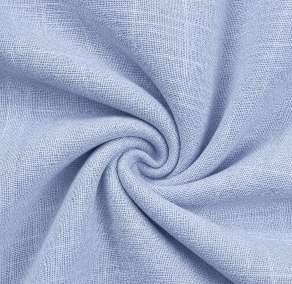 Light blue textured fabric with a subtle woven pattern, arranged in a spiral drape to show its softness and weave detail.