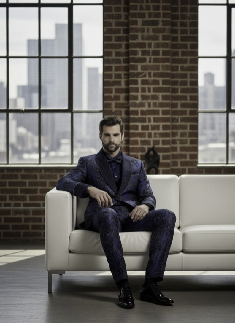Man in a dark suit sitting on a white couch with a cityscape in the background