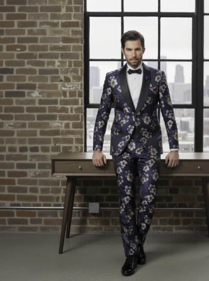 Man_in_a_floral_suit_standing_in_front_of_a_window_with_a_cityscape_view.