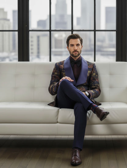 Man in a stylish outfit sitting on a white couch with a cityscape in the background