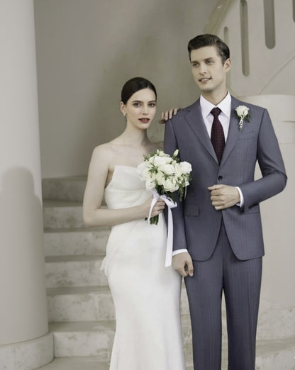 Man in a suit and woman in a wedding dress standing on a staircase