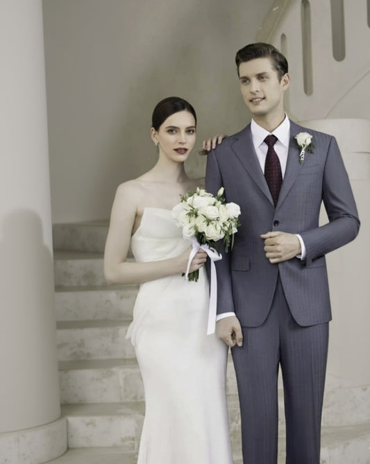 Man in a suit and woman in a wedding dress standing on a staircase