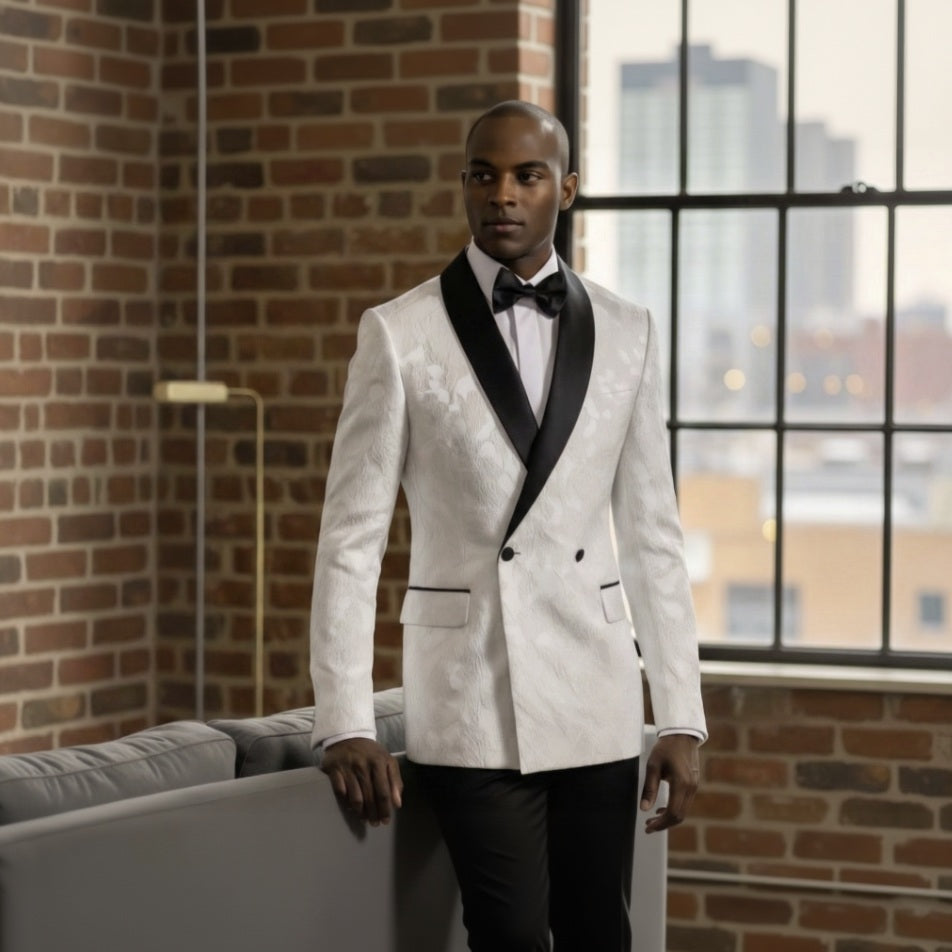 Man_in_a_white_suit_standing_in_a_room_with_large_windows_and_brick_wall