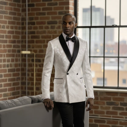 Man_in_a_white_suit_standing_in_a_room_with_large_windows_and_brick_wall