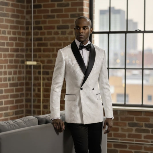 Man_in_a_white_suit_standing_in_a_room_with_large_windows_and_brick_wall