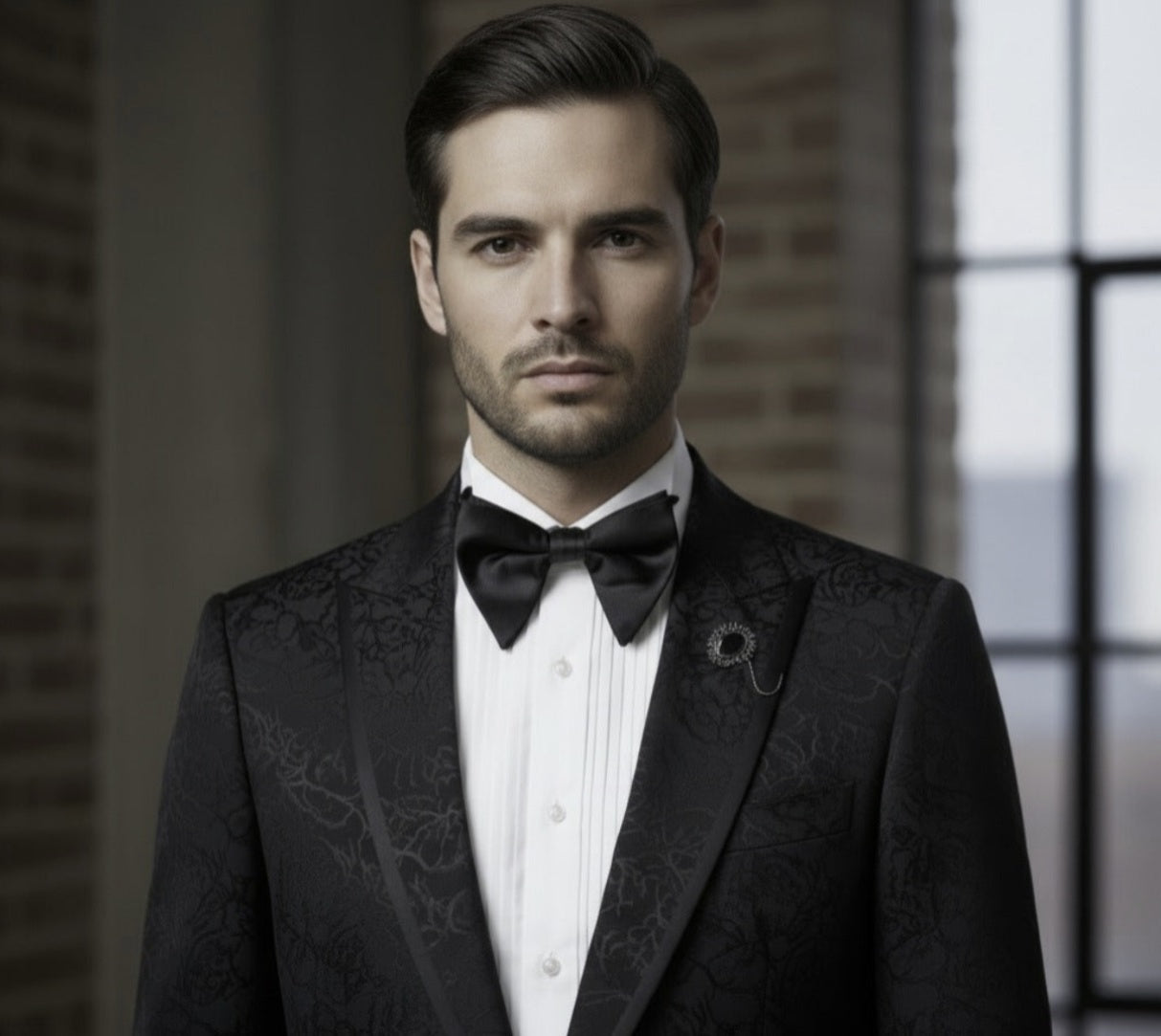 Man wearing a black tuxedo with a bow tie in an indoor setting.