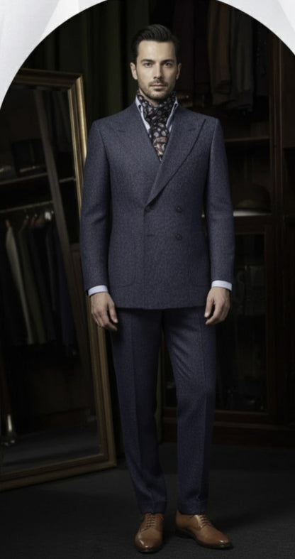 Man wearing a blue suit with a patterned tie in a darkly lit room.