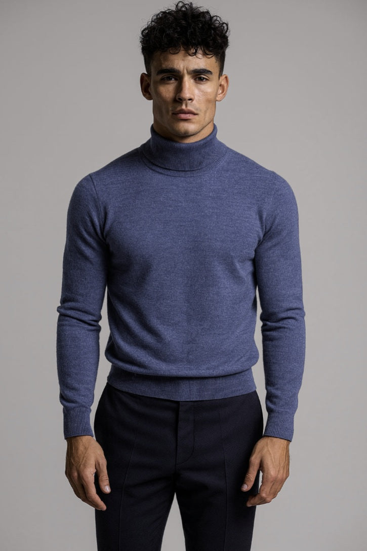 Man wearing a blue turtleneck sweater against a gray background