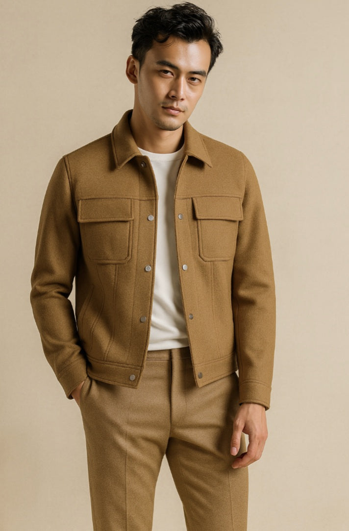 Man wearing a brown jacket and beige pants against a beige background