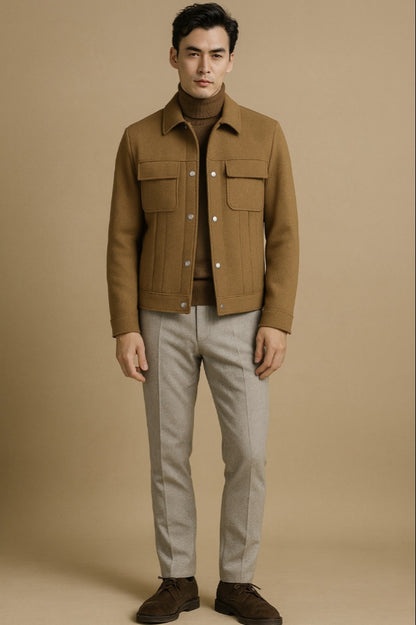 Man wearing a brown jacket and light grey pants against a beige background

