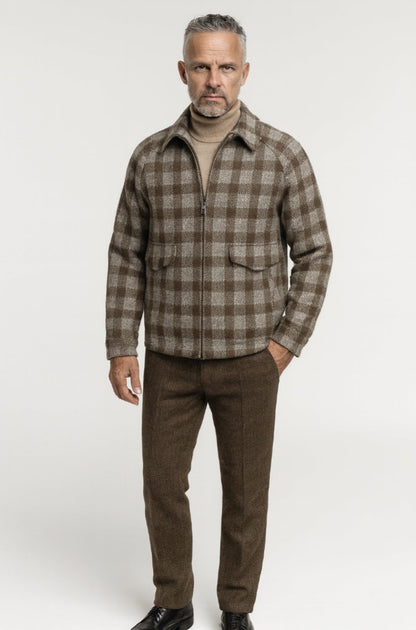 Man wearing a brown plaid shirt and pants on a white background
