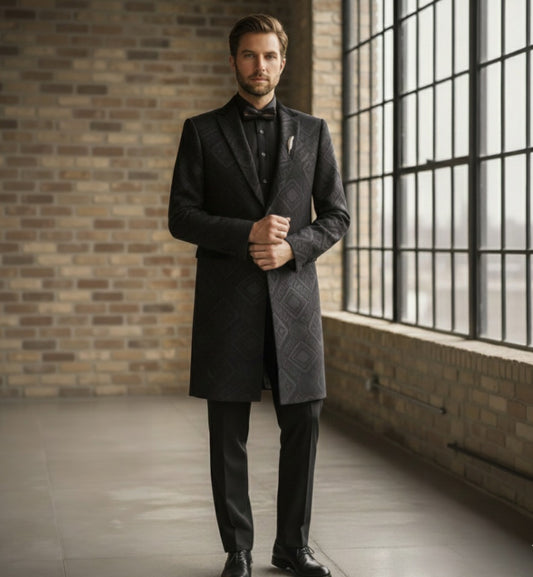 Man_wearing_a_dark_black_overcoat_with_a_brick_wall_and_large_window_in_the_background